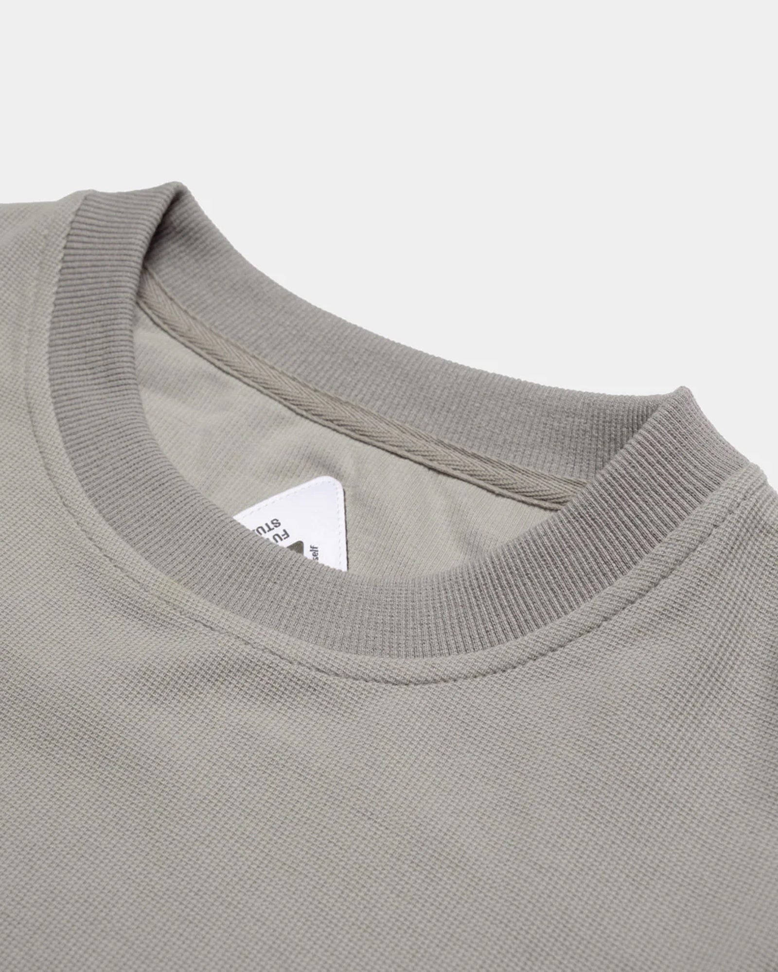 A Eckhaus Latta Shirt pictured on a model in front of a white background. The title of the product is Eckhaus Latta Eclipse Turtleneck - Stone and the image was taken by 199A®.